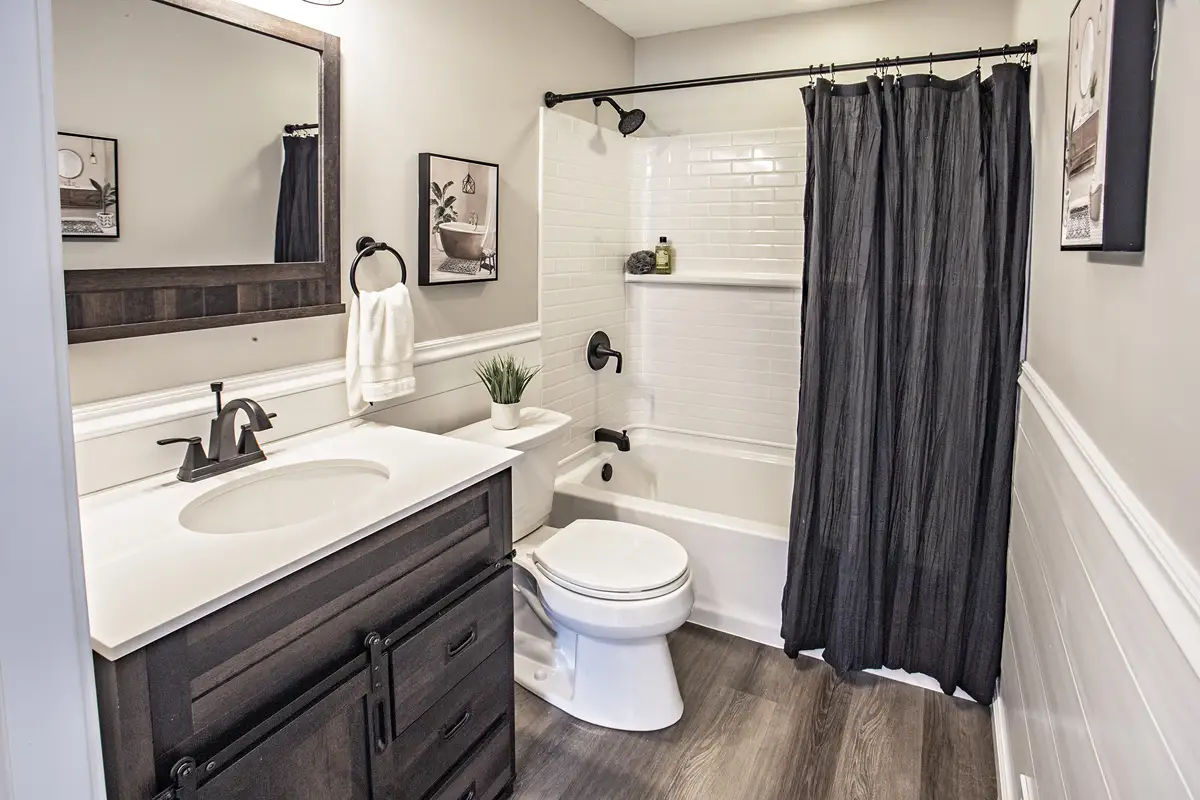 Bathroom with dark cabinet and shower curtain.