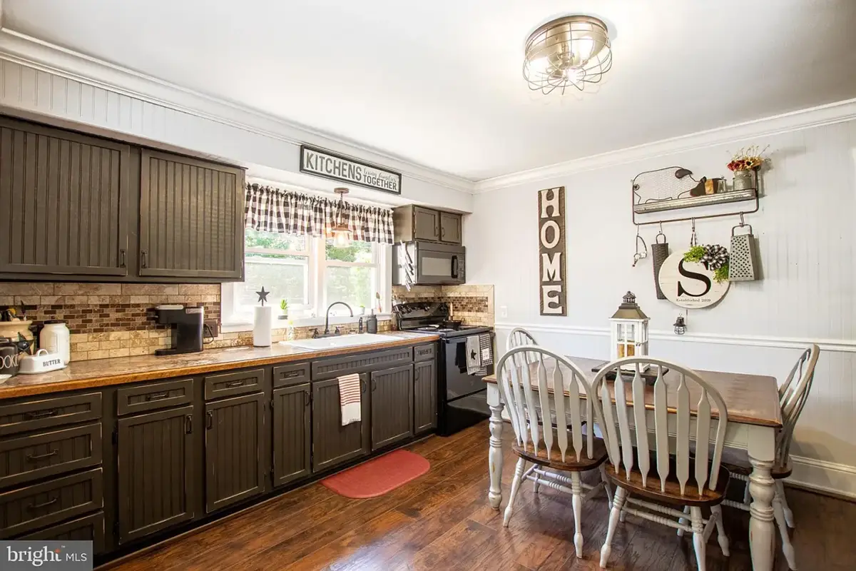 Kitchen with dark cabinets and wood floor.