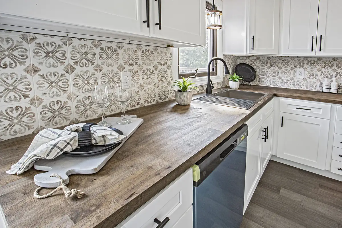 New kitchen counters with gray wood flooring.