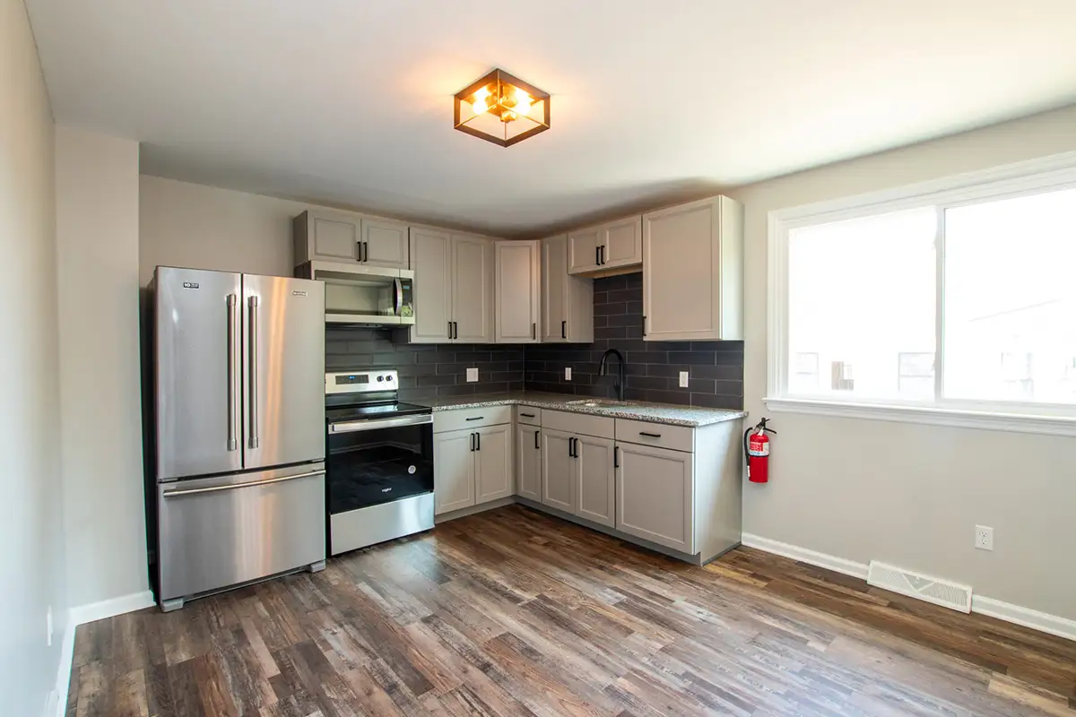 Kitchen with stainless appliances and floor to ceiling cabinets.