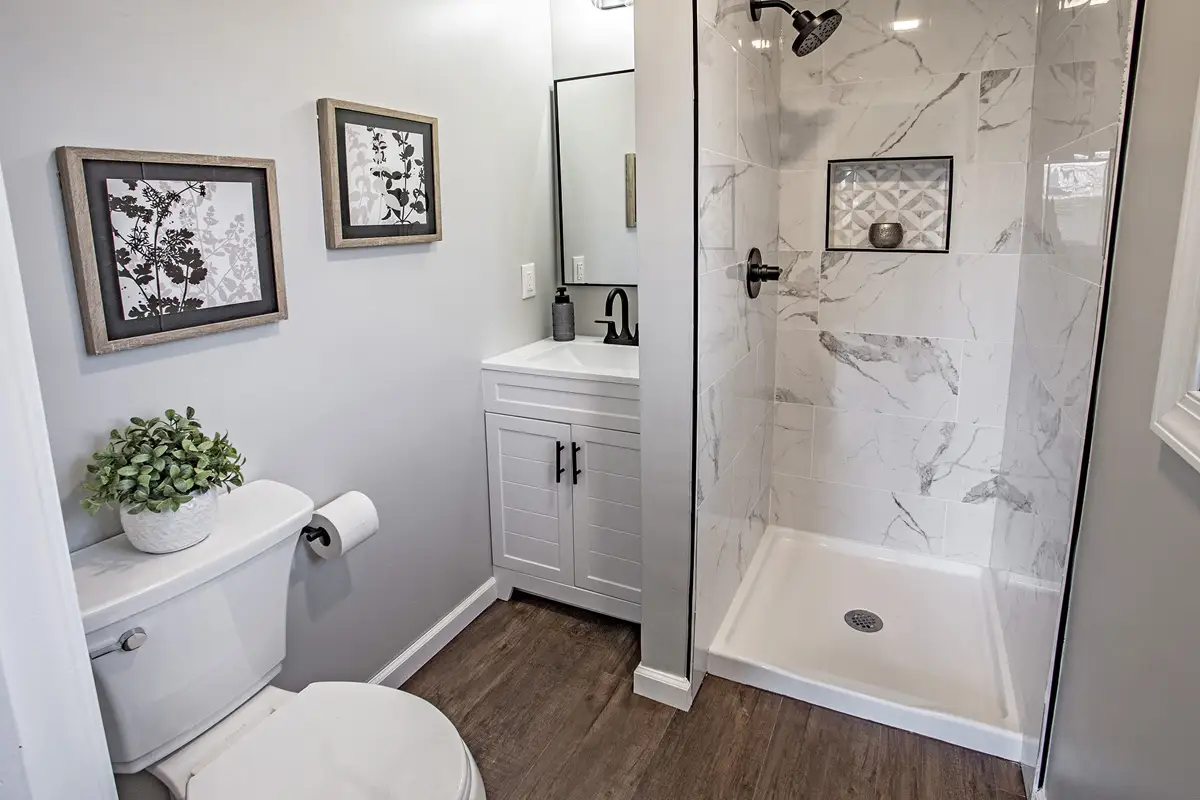 Bathroom with walk in shower with marble walls.