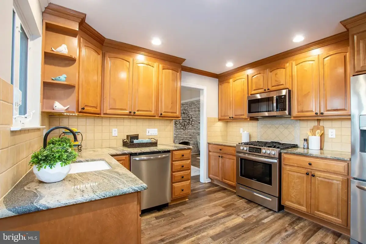 Kitchen with light wood floor to ceiling cabinets.